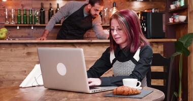 Woman enjoys coffee while working in vintage and stylish coffee shop or pub video