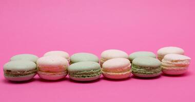 Different type of sweet macaroons dessert on pink background in studio video