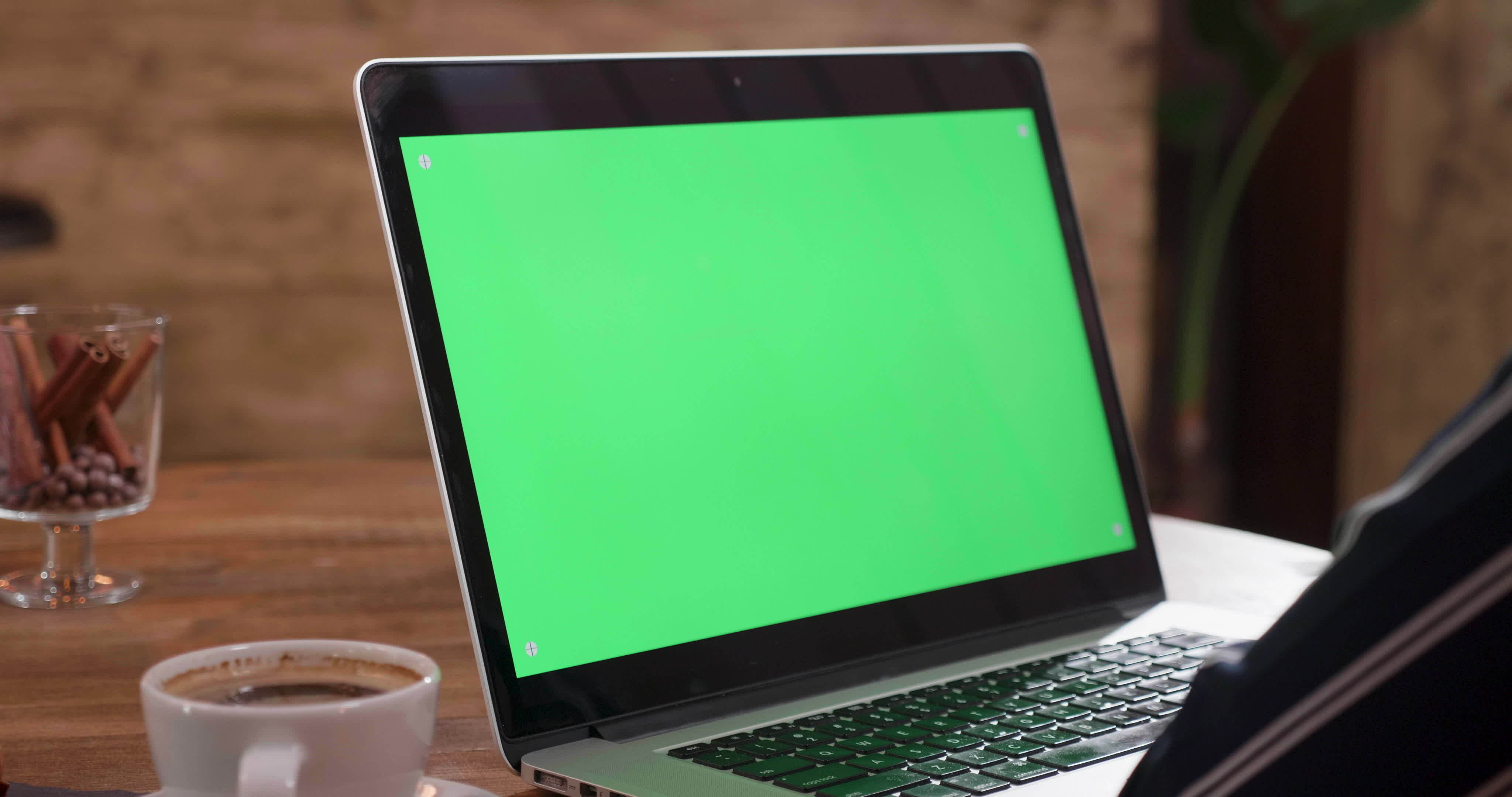 Looking At The Laptop With A Green Screen On In A Small Bar Costumers looking-at-the-laptop-with-a-green-screen-on-in-a-small-bar-costumers