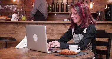 trabajando en ordenador portátil en Clásico elegante pub o café tienda y disfrutando un taza de café o té video