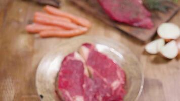 General, out of focus shot sliding towards a chunk of raw meat. Vintage plate and wooden surface. video