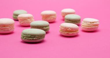 Multiple delicious sweet macaroons dessert on pink background video