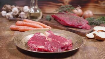 Fresh ribeye steak with vegetables in the background. Raw meat ready for cooking. video