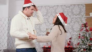 contento sorridente coppia Tenere Champagne bicchiere nel mani danza e avendo divertimento nel Natale decorato camera, lento movimento vicino su tiro video