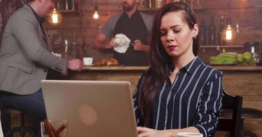 diapositiva tiro a partire dal giusto per sinistra di un' bella donna focalizzata digitando un' testo su sua computer. lei è comporre un' testo e sorrisi bene. video