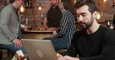 de cerca retrato de un joven persona de libre dedicación mecanografía y pensando acerca de el texto en su computadora. caucásico masculino contemplando terminado un correo electrónico. video