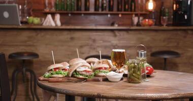 glissement vers une agréable composition de des hamburgers avec sauce et bière. dans une ancien style pub. portion vite nourriture dans une restaurant. video