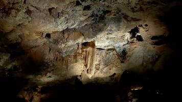 grotta stalaktiter upplyst förbi ljus. en grotta med stalaktiter på de tak video