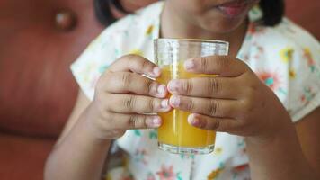 kind hand- Holding een glas van oranje sap video