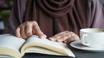 women hand reading a book at library video