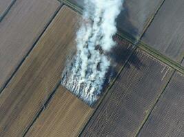 Burning straw in the fields after harvesting wheat crop photo