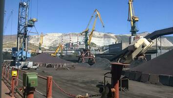 Cargo industrial port, port cranes. Loading of anthracite. Transportation of coal. Heap of coal photo