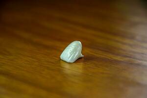 Tooth, metal ceramic crown on the table. Denture made of metal ceramics photo