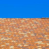 Roof from multi-colored bituminous shingles. Patterned bitumen shingles. photo