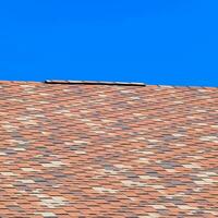 Roof from multi-colored bituminous shingles. Patterned bitumen shingles. photo