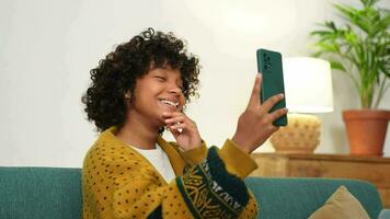 African american girl holding smartphone having video chat. Female blogger chatting with best friends in social network. Young woman having virtual meeting online chat video call at home