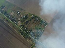 Top view of the small village. Smoke from the burning of straw is spread over the village photo