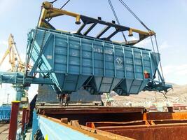 Raising the hopper car for unloading on a cargo ship. Lifting operations in the port. photo