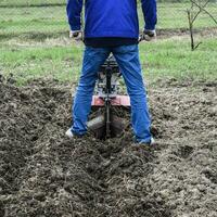 plantando patatas debajo el con operador a pie tractor foto