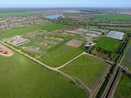 Rural landscape. View from above. On the horizon there is a poultry farm, a field, forest belts and a river photo
