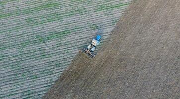 Top view of the tractor that plows the field. disking the soil. Soil cultivation after harvest photo