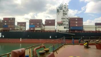 un Embarcacion con carga contenedores en tablero. ver de el carga Embarcacion desde el cubierta de el amarradero sitio foto