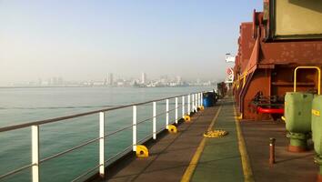 View of the sea and city beach from the port quay. Industrial port with tower cranes and cargo infrastructure photo