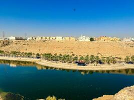 A beautiful daytime view of Wadi Namar Dam in riyadh , Saudi Arabia. The water of the dam and the surrounding hills are presenting a beautiful scene in the sunlight. photo
