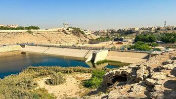 A beautiful daytime view of Wadi Namar Dam in riyadh , Saudi Arabia. The water of the dam and the surrounding hills are presenting a beautiful scene in the sunlight. photo