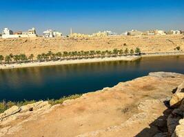 A beautiful daytime view of Wadi Namar Dam in riyadh , Saudi Arabia. The water of the dam and the surrounding hills are presenting a beautiful scene in the sunlight. photo