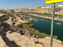A beautiful daytime view of Wadi Namar Dam in riyadh , Saudi Arabia. The water of the dam and the surrounding hills are presenting a beautiful scene in the sunlight. photo