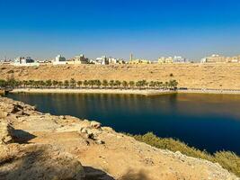 A beautiful daytime view of Wadi Namar Dam in riyadh , Saudi Arabia. The water of the dam and the surrounding hills are presenting a beautiful scene in the sunlight. photo
