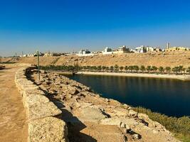 un hermosa tiempo de día ver de cauce namar represa en riyadh , saudi arabia el agua de el represa y el rodeando colinas son presentación un hermosa escena en el luz de sol. foto