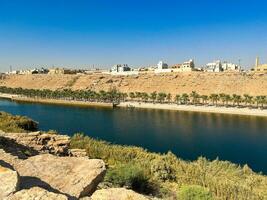 A beautiful daytime view of Wadi Namar Dam in riyadh , Saudi Arabia. The water of the dam and the surrounding hills are presenting a beautiful scene in the sunlight. photo