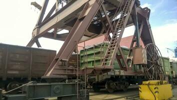 Loaded freight cars in the port. Passage of cars under the tower crane photo