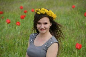 A girl with a wreath of dandelions on her head. Beautiful fairy photo