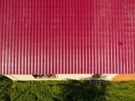 A house with a red roof made of corrugated metal sheets. Roof from corrugated metal profile. Metal tiles. photo