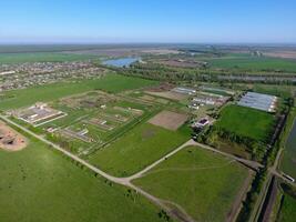 Rural landscape. View from above. On the horizon there is a poultry farm, a field, forest belts and a river photo