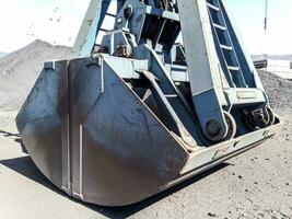 Clamshell bucket in the cargo port. Bucket for loading coal photo