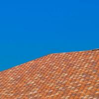 Roof from multi-colored bituminous shingles. Patterned bitumen shingles. photo