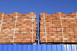 Red bricks stacked into cubes. Warehouse bricks. Storage brickwo photo