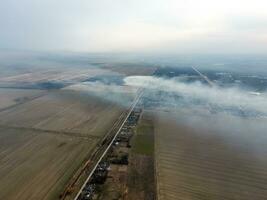 Top view of the small village. Smoke from the burning of straw i photo