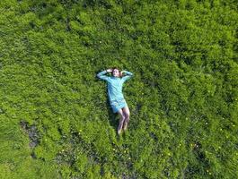 The girl lies in a turquoise dress on the lawn. beautiful girl lying down of grass photo