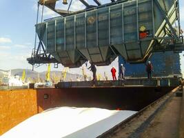 Wagon of the hopper for unloading on a cargo ship. Lifting operations in the port. photo