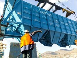 Raising the hopper car for unloading on a cargo ship. Lifting operations in the port. photo