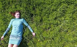 The girl lies in a turquoise dress on the lawn. beautiful girl l photo