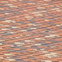 Roof from multi-colored bituminous shingles. Patterned bitumen shingles. photo