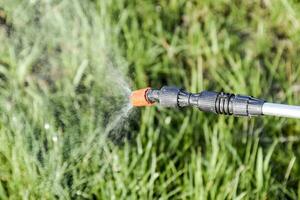 Spraying herbicide from the nozzle of the sprayer manual photo