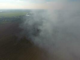 Top view of the small village. Smoke from the burning of straw is spread over the village photo