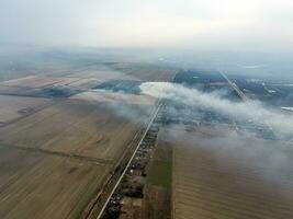 Top view of the small village. Smoke from the burning of straw i photo